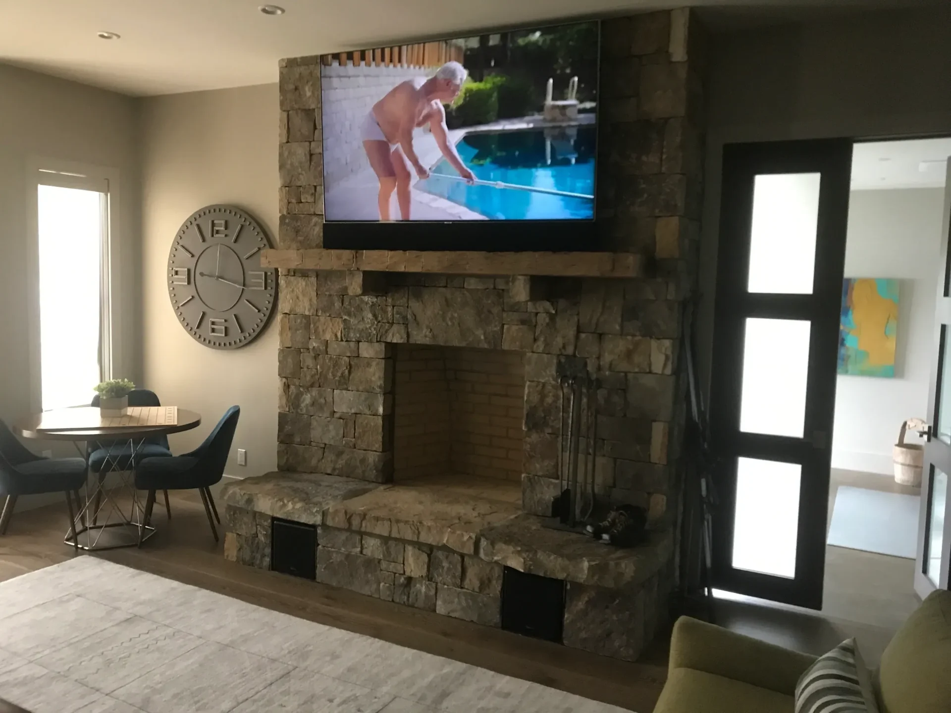 Living room with stone fireplace and TV.