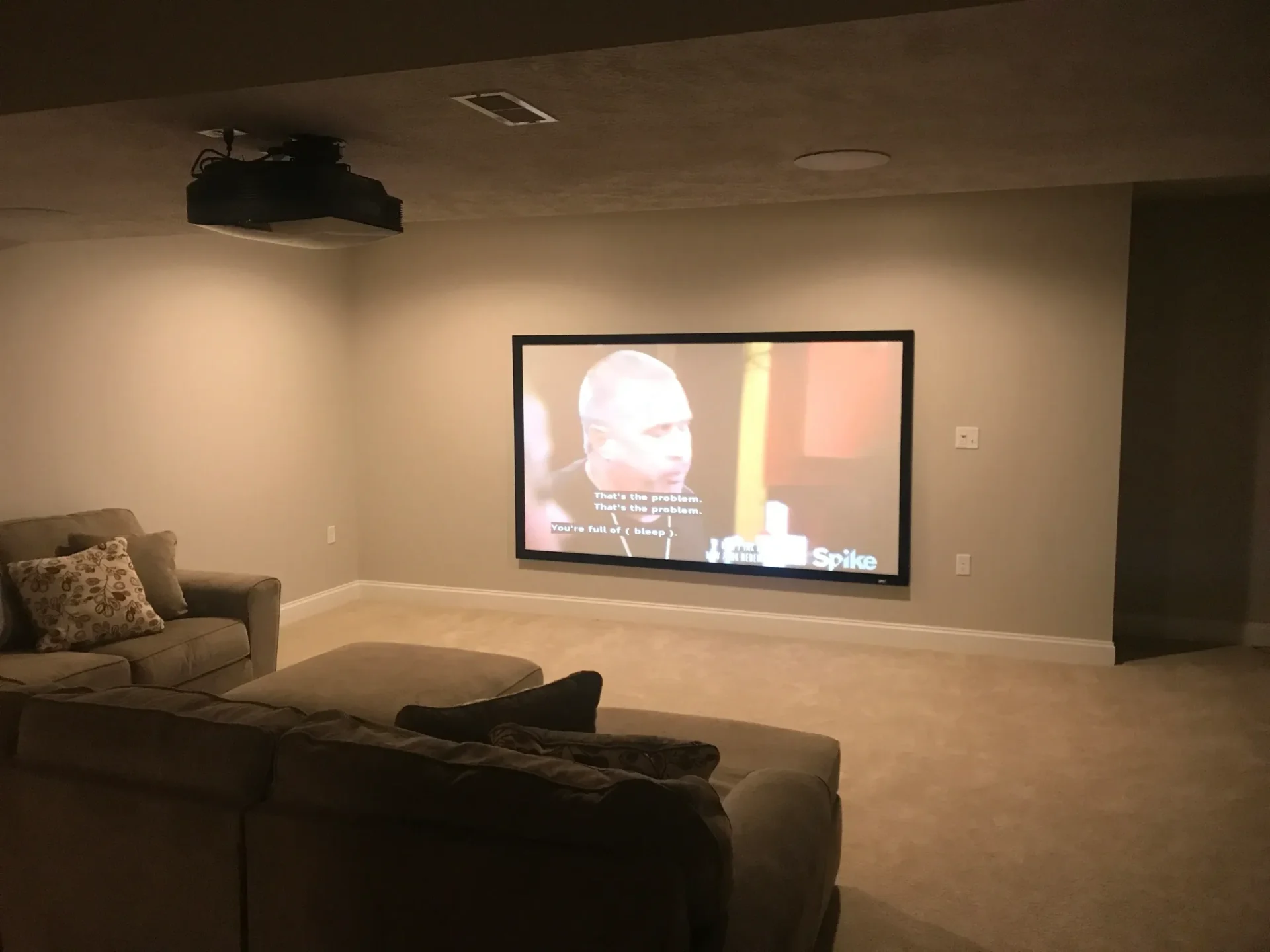 Home theater with large screen and sofa.
