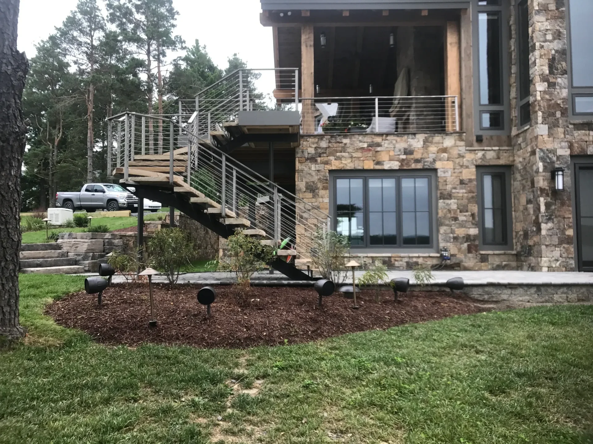 Stone house with outdoor staircase and garden.