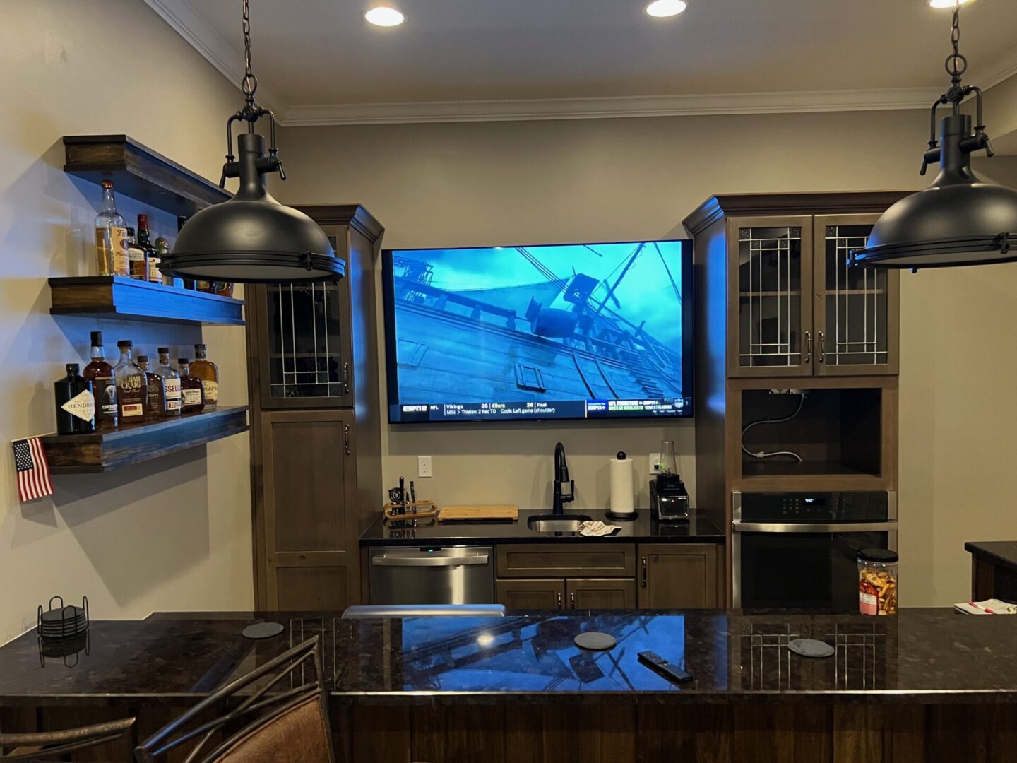 Modern kitchen with a large TV and birdcage.