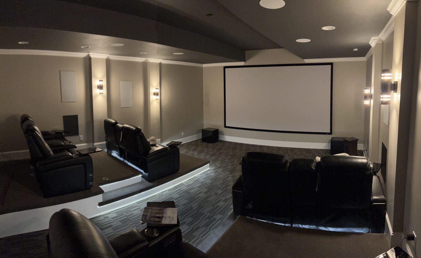 Cozy home theater with plush seating and a large screen.
