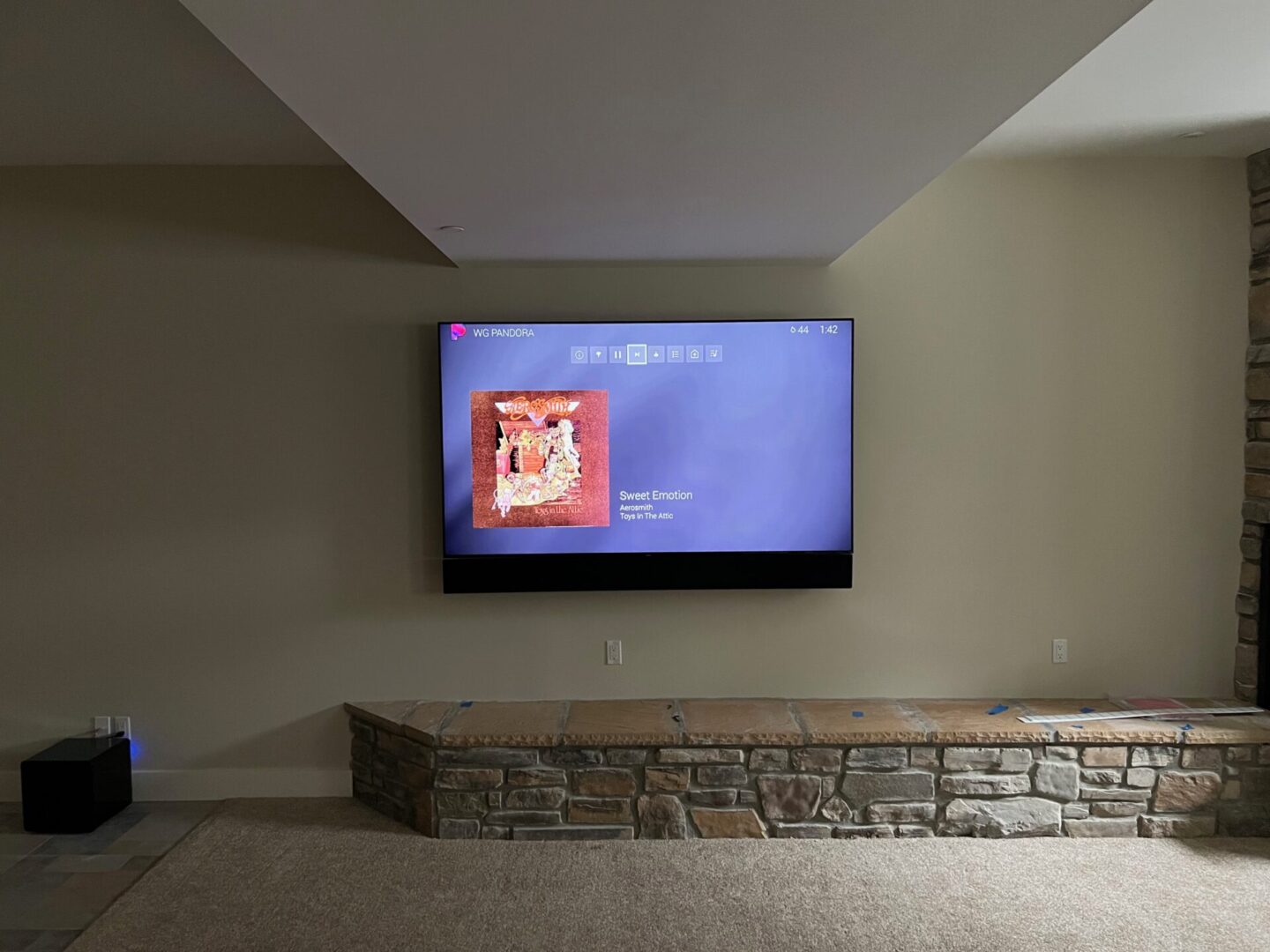 TV mounted on wall displaying a paused video.