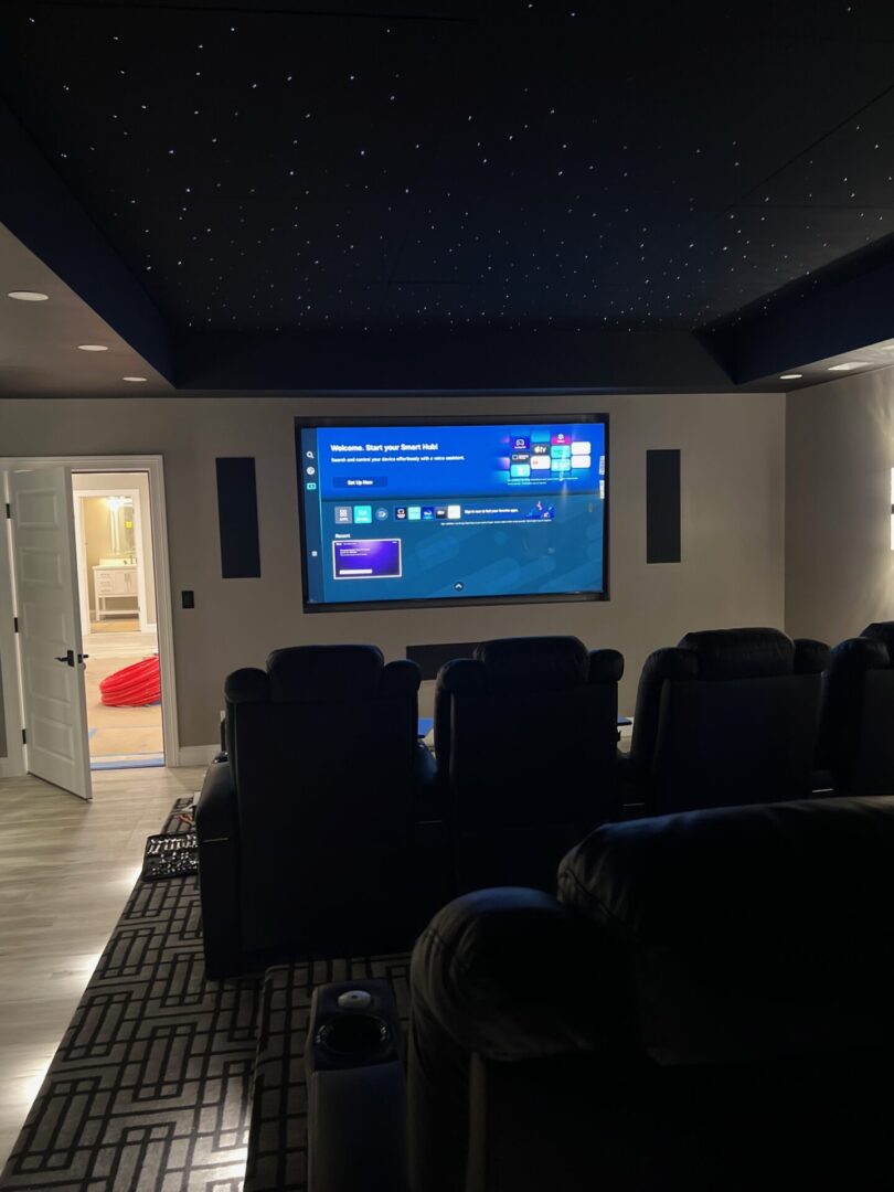 Home theater room with large screen and recliner seating.