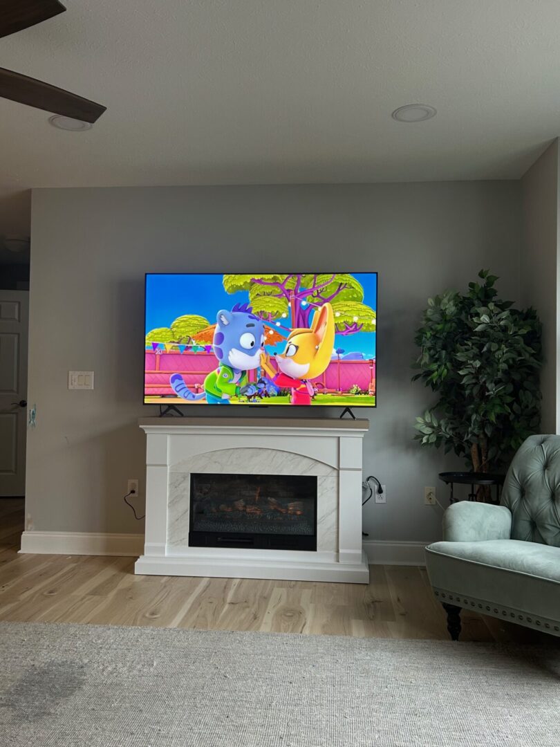 A colorful cartoon playing on a TV above a white fireplace.
